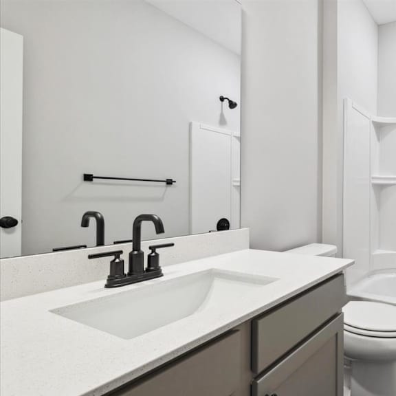 a white bathroom with a toilet, sink, and bathtub.