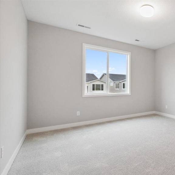 a room with a window showing a house across the way.