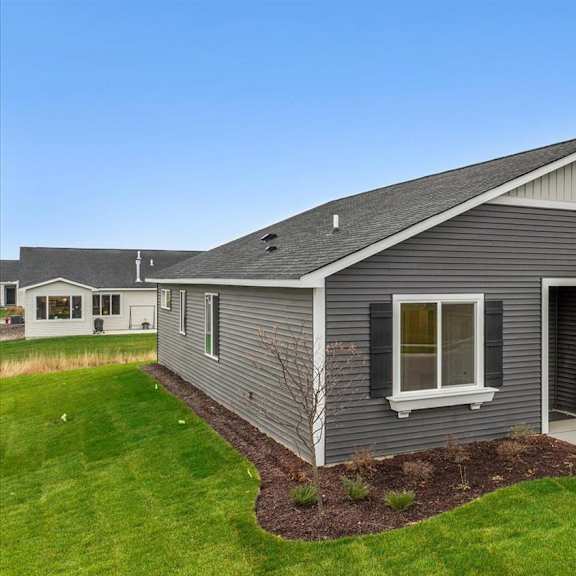a grey house with a white garage door and a window.