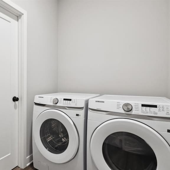 two white front loading washing machines in a laundry room.
