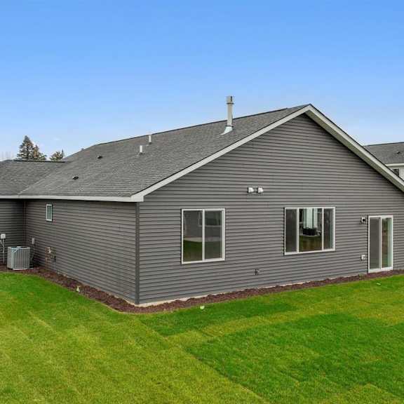 a grey house with a white house in the background.