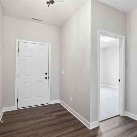 a white door is in the middle of a room with wood flooring.