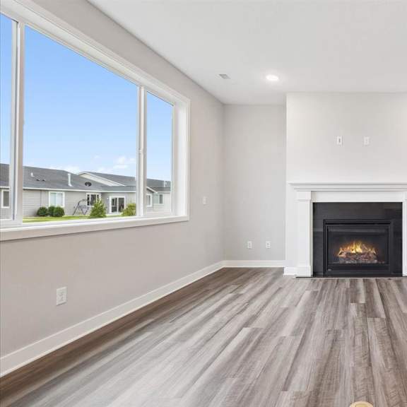 a spacious living room with a fireplace and hardwood floors.