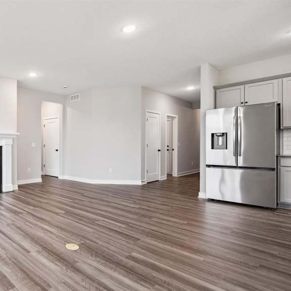 a modern kitchen with a fireplace and wooden floors.