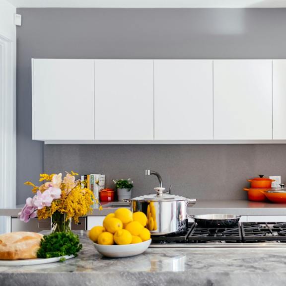 a modern kitchen with a marble countertop and a stove top oven.