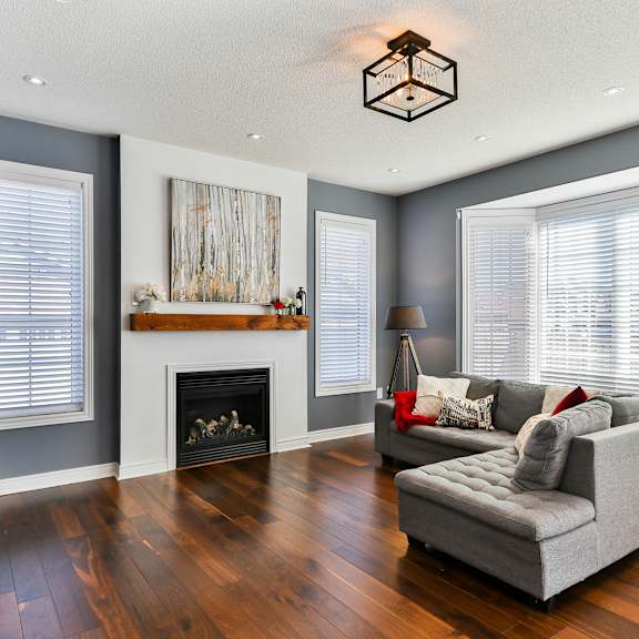 a living room with a grey couch and a fireplace.