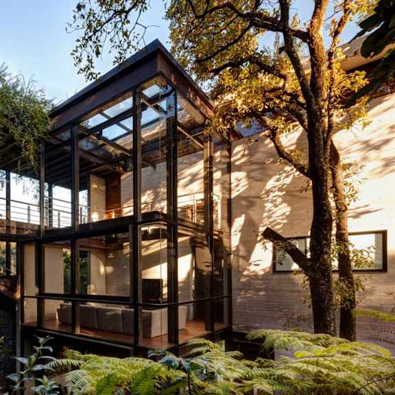 a glass bridge connects the two volumes of a house