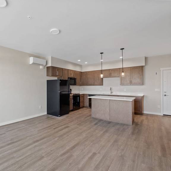 a kitchen with a black refrigerator and a white countertop.