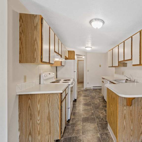 a kitchen with wood cabinets and white counter tops
