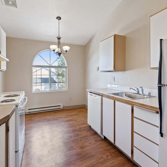 image of the kitchen with sink, refrigerator, stove, and cabinets.