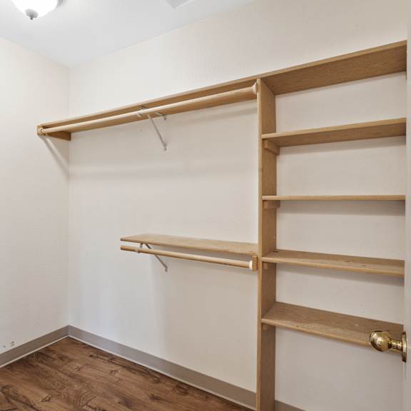 a walk in closet with wooden shelves and a door