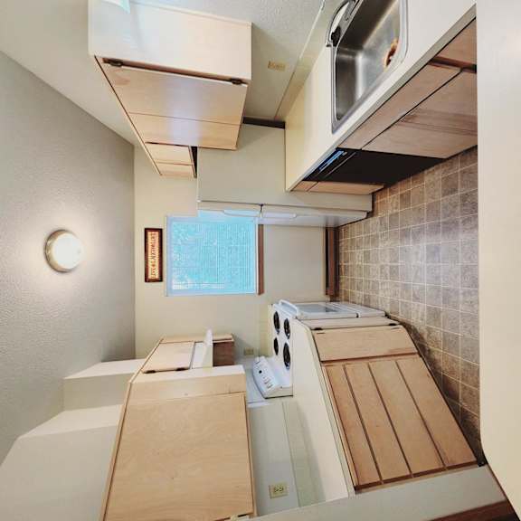 a kitchen with wooden cabinets and a stove and a sink