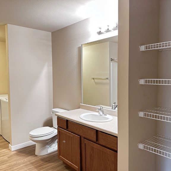 a bathroom with a toilet, sink, and mirror.