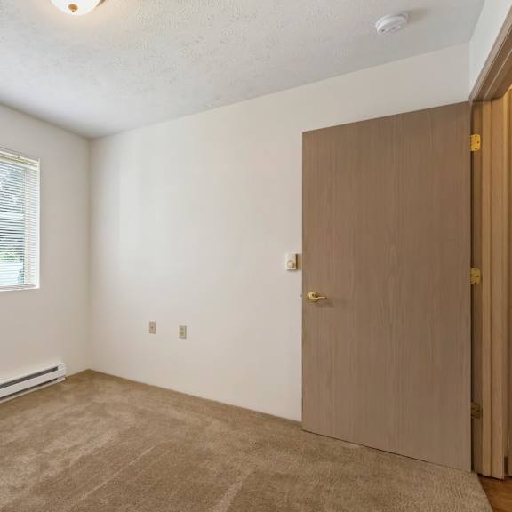 an empty room with a door and a window