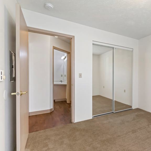 an empty living room with a sliding glass door to a bathroom