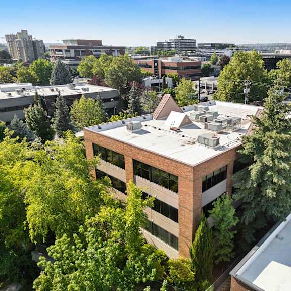 an aerial view of a building with a city in the background