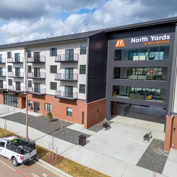 a white truck is parked in front of a building with a sign that says north yards.