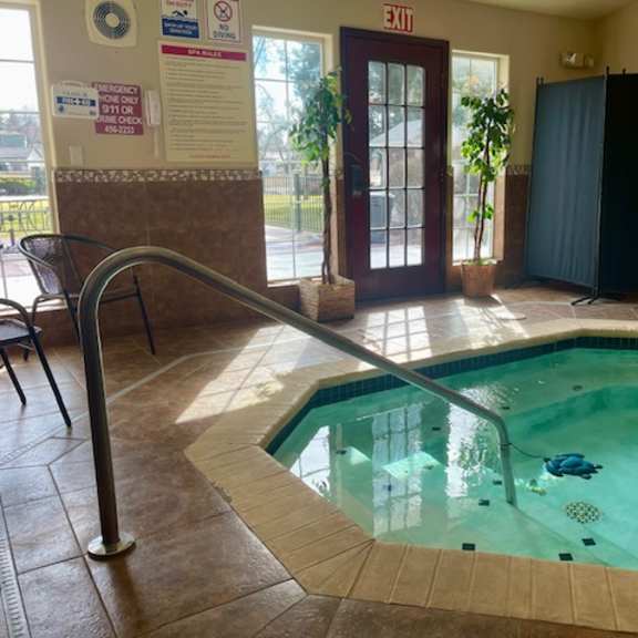 a small indoor pool with a metal ladder.