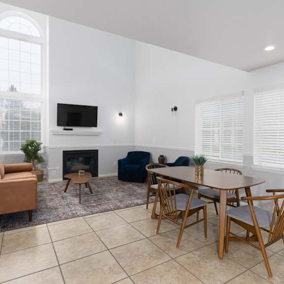 a living room with a table and chairs and a fireplace