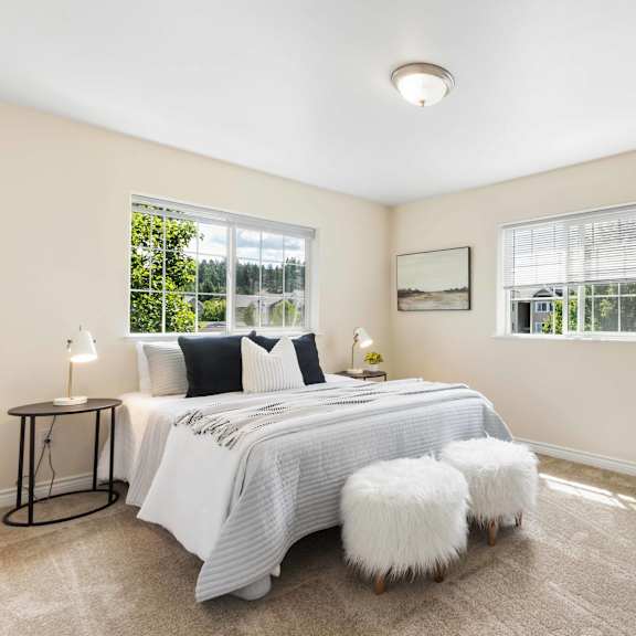 a bedroom with a bed and two windows