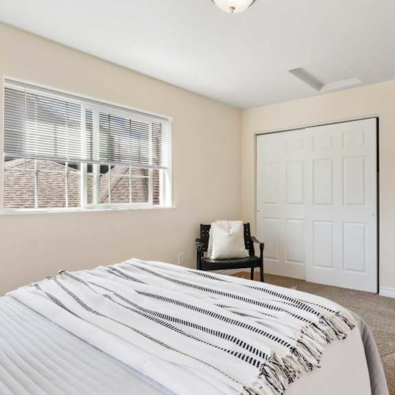 a bedroom with a bed and a closet and a window