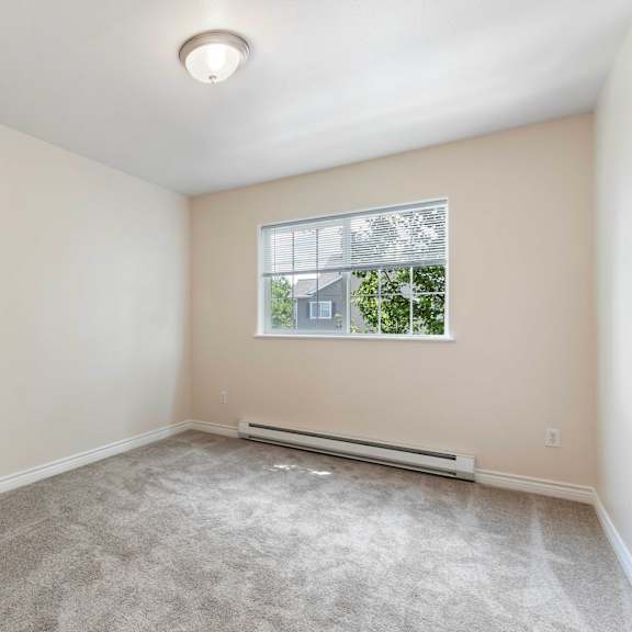 an empty room with carpet and a window