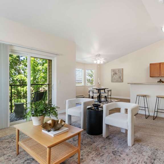 a living room with a island bar and a kitchen with stools