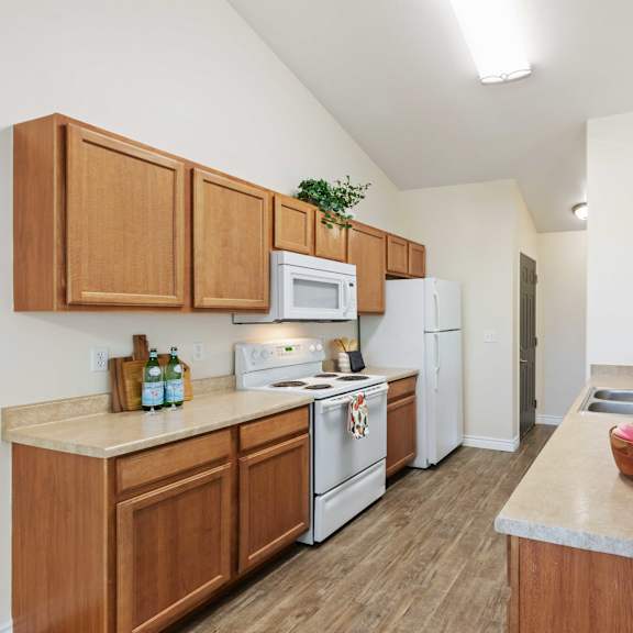 a large kitchen with white appliances and wooden cabinets