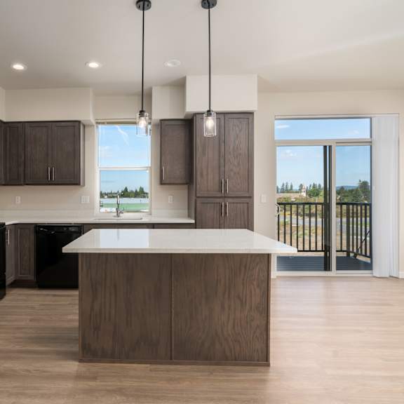 a modern kitchen with a black refrigerator and wooden cabinets.