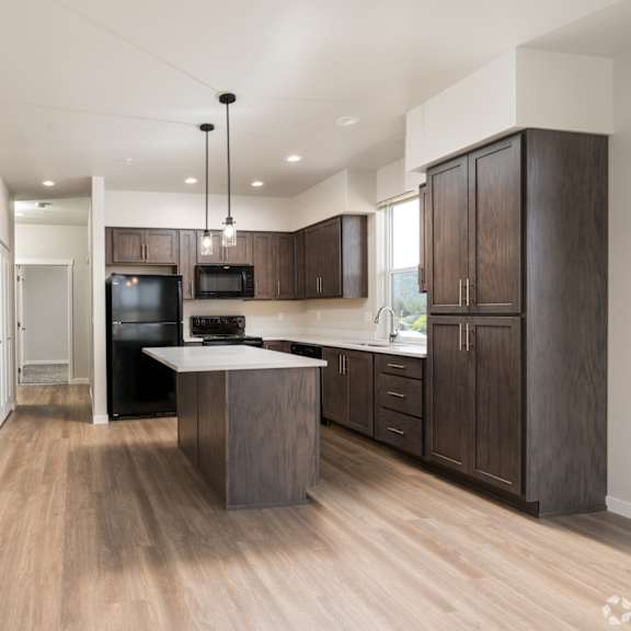a modern kitchen with wooden floors and cabinets.