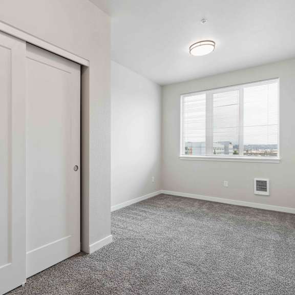 a room with a white door and a window with a view of buildings outside.