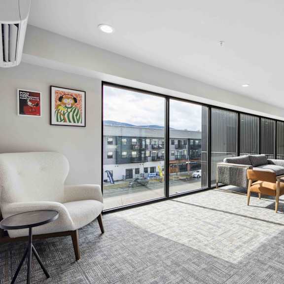 a room with a white chair and a grey carpet.