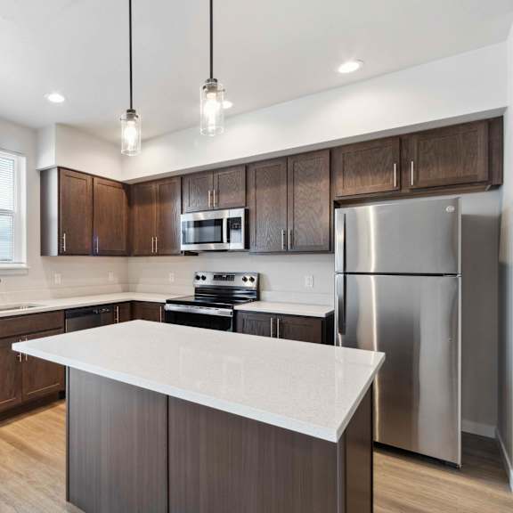 a modern kitchen with dark wood cabinets and stainless steel appliances.