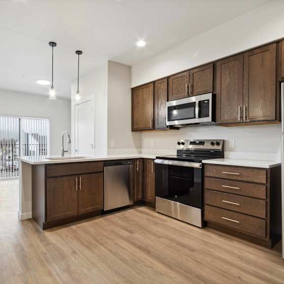 a modern kitchen with wooden cabinets and stainless steel appliances.