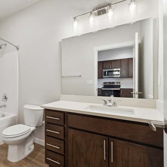 a white bathroom with a toilet, sink, and a mirror.