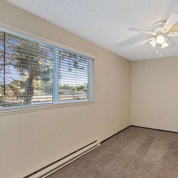 a room with a window and a ceiling fan.