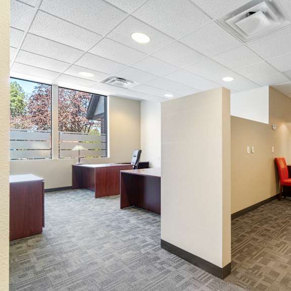 a room with chairs and a desk and a window