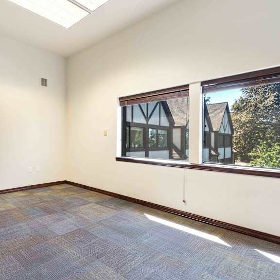 an empty living room with a large window and a door