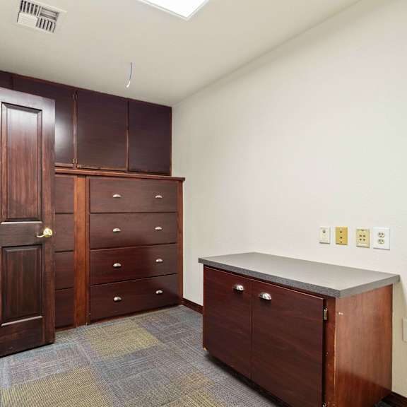 a laundry room with wooden cabinets and a counter