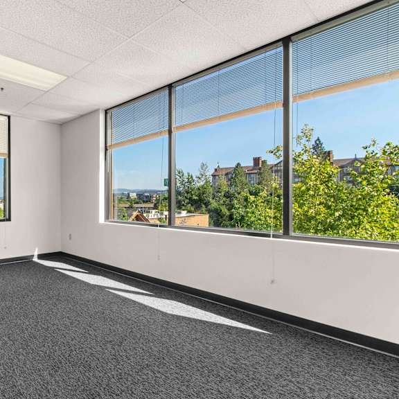 an empty office space with large windows and a city view