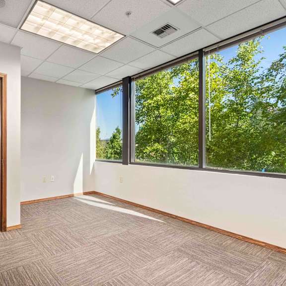 an empty office space with large windows and a door