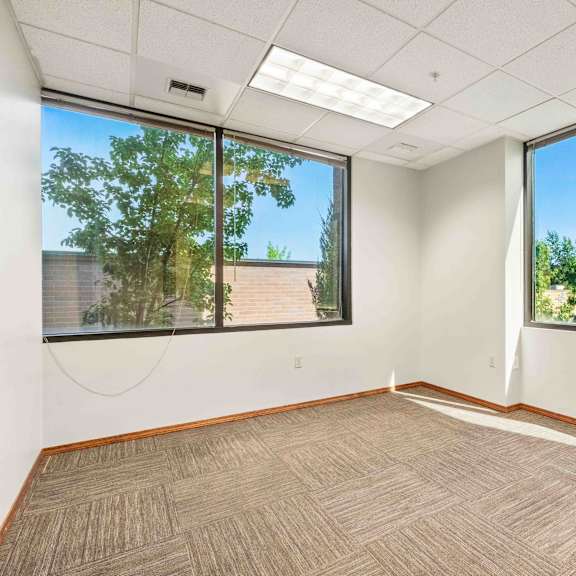 an empty room with three large windows