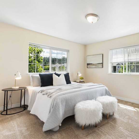 a bedroom with a large bed, a bench, and a window.