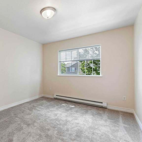 a room with a window and a carpeted floor.