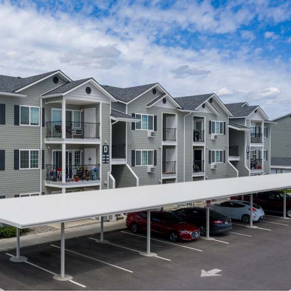 a parking lot in front of a building with a white canopy.