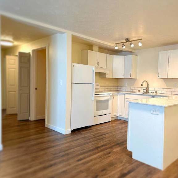 a kitchen with white appliances and cabinets.