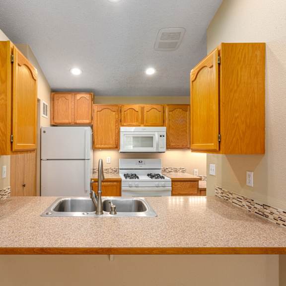a kitchen with wooden cabinets and a white refrigerator.
