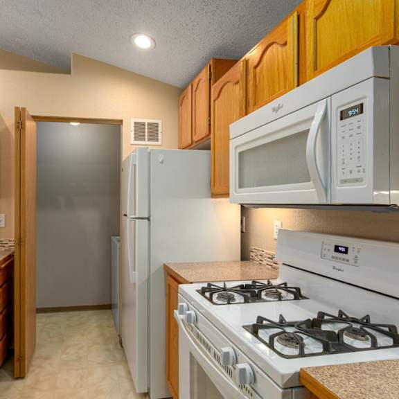 a kitchen with a stove, sink, and refrigerator.
