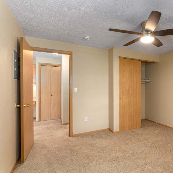 a room with a ceiling fan and two doors.