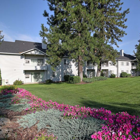 the view of an apartment building with a lawn and trees